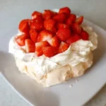 Air Fried Meringue In a white plate and there are strawberries on it